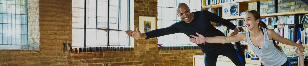 father and daughter doing yoga at home