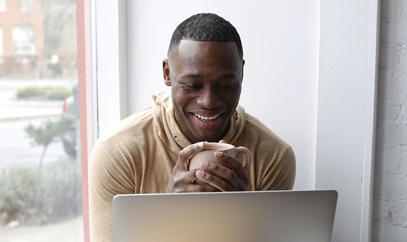 Hispanic man paying bills online in kitchen