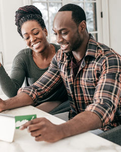 Pareja afroamericana sonriente sentada en una mesa