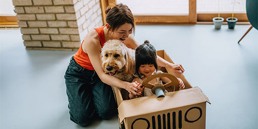 mother, daughter, and dog having fun in a box car