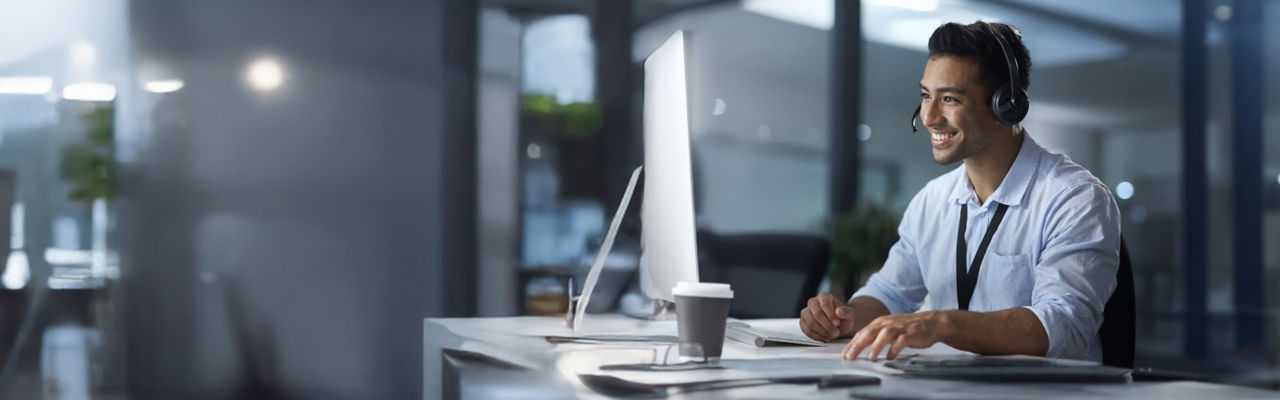 sales marketer with headphones on computer