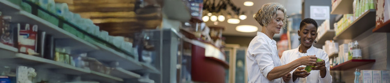 senior looking at an item in the pharmacy aisle