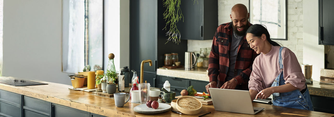 two millenials cooking in kitchen