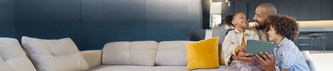 father with two young kids holding an ipad