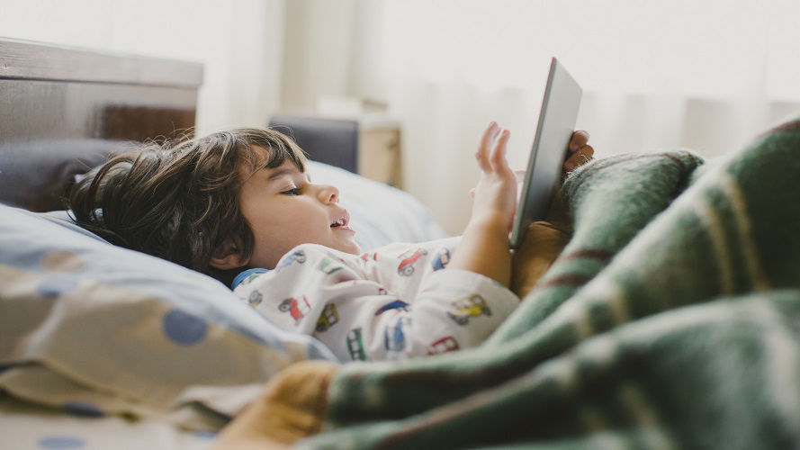 niño en la cama con tableta