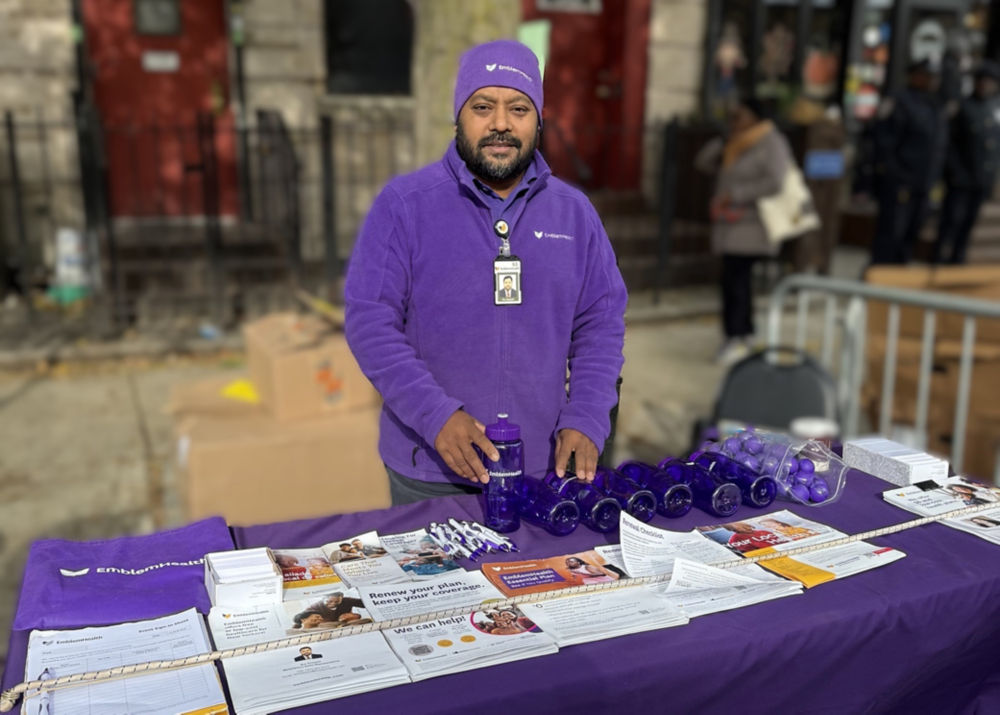 Representante de inscripción facilitada de EmblemHealth, Nur Hossain, en el Festival de la Cosecha. 