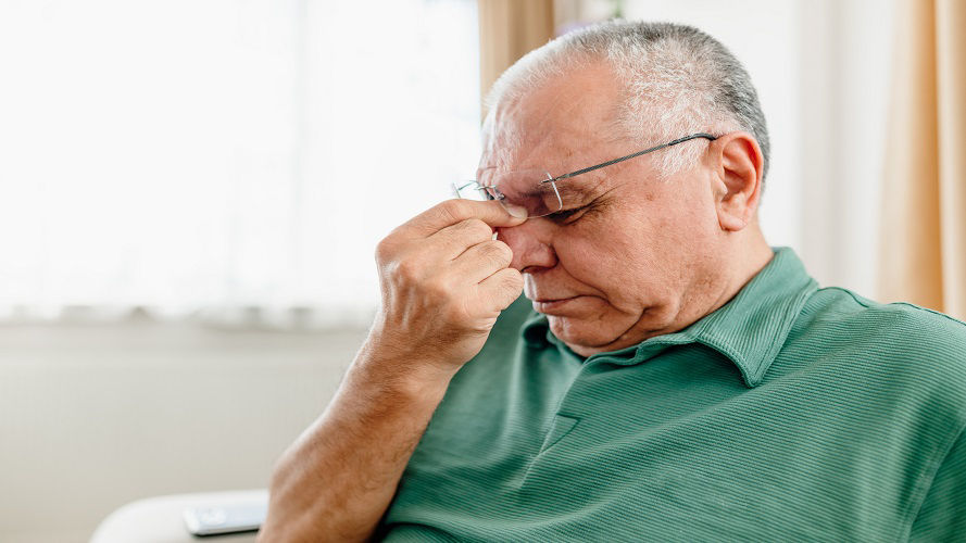 Un adulto mayor angustiado sufriendo por una migraña