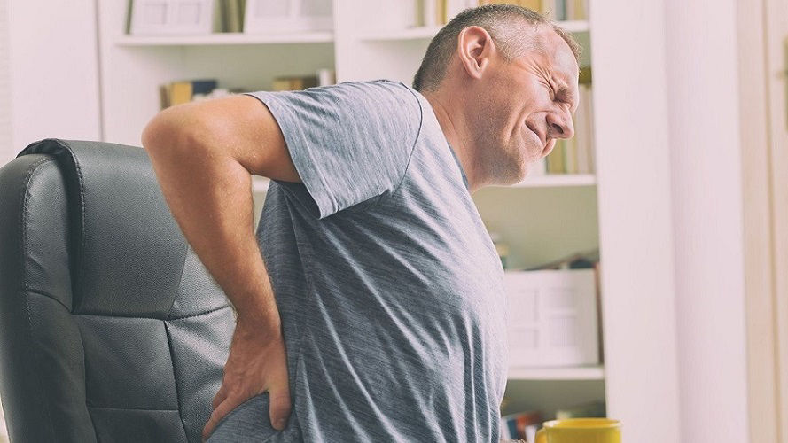 man with back pain in chair