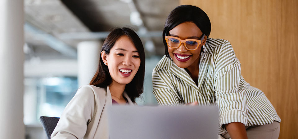 dos mujeres mirando una computadora.