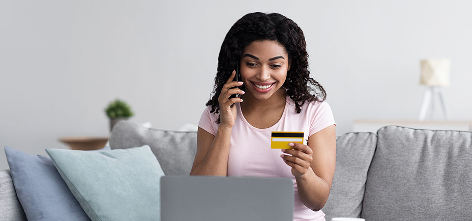 woman on phone and holder card at computer 