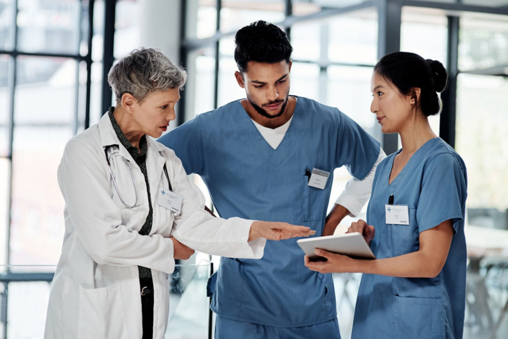 Shot of a group of medical practitioners using a digital tablet together in a hospital