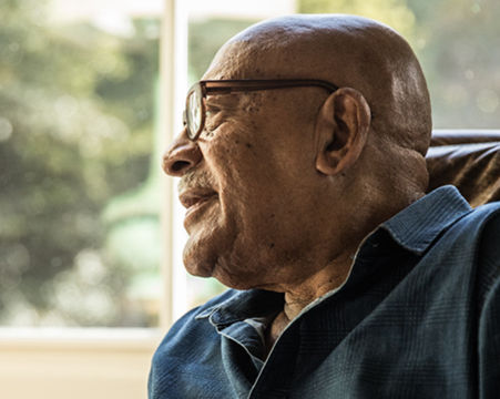 man sitting in a chair looking out the window