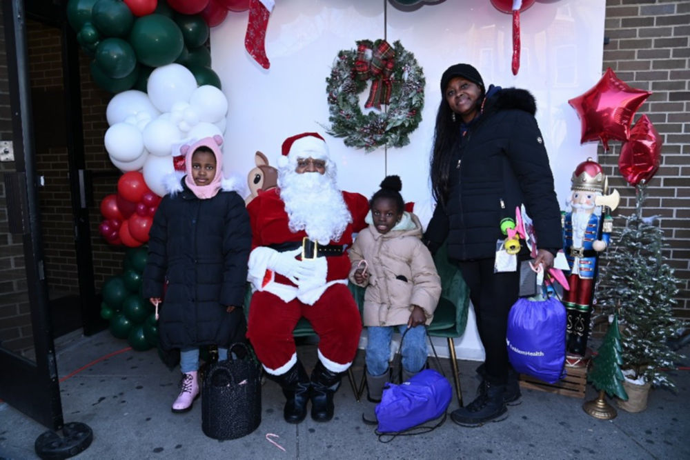 Una familia posa junto a Papá Noel en EmblemHealth Winter Wonderland.