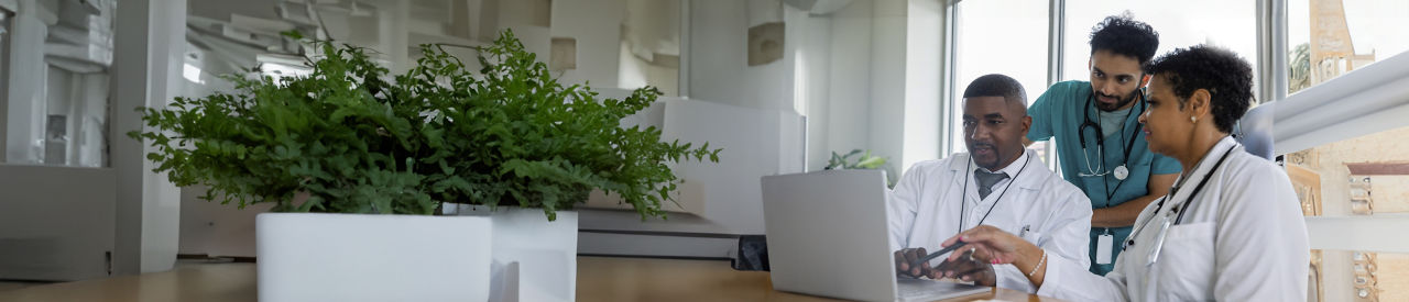 group of healthcare providers looking at laptop in office