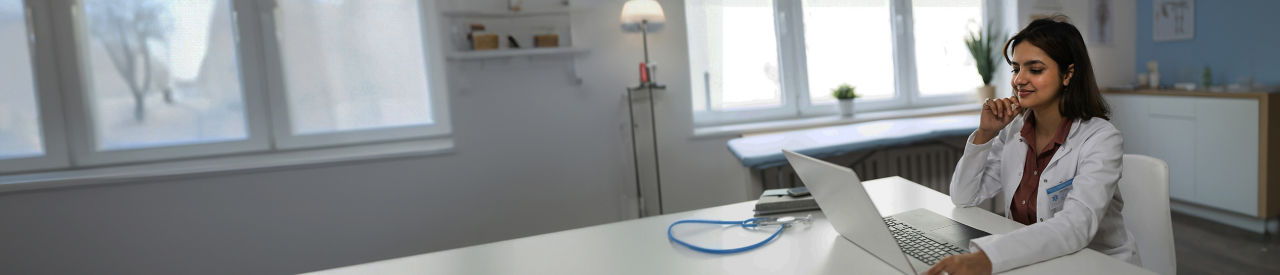 healthcare provider looking at laptop in office