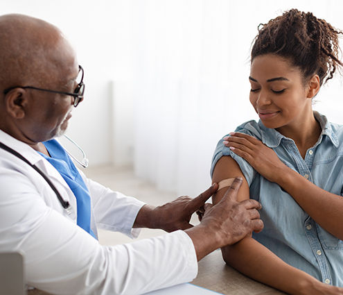 médico que administra una vacuna a un paciente en el consultorio médico