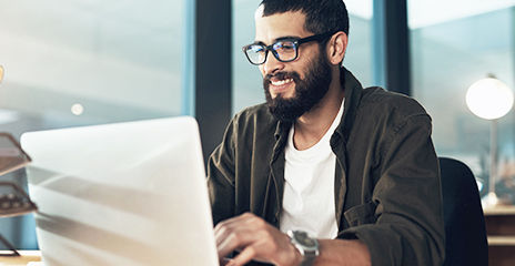 Un hombre de negocios joven usa una computadora portátil en una oficina moderna