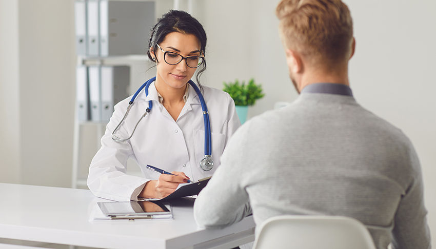 Female doctor therapist gross allergist nutritionist otolaryngologist and male patient sitting at a table in a clinic office. Medicine clinic hospital.