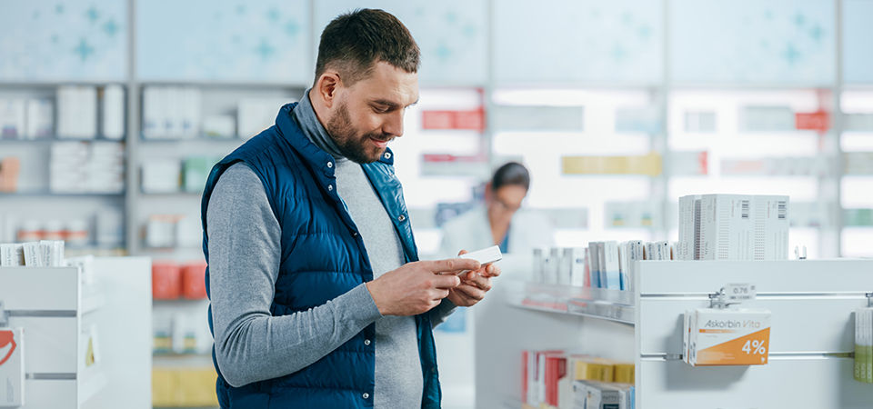 Man looking at medicine in. the pharmacy