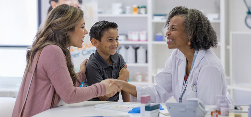 mom and son talking to the pharmacist and smiling