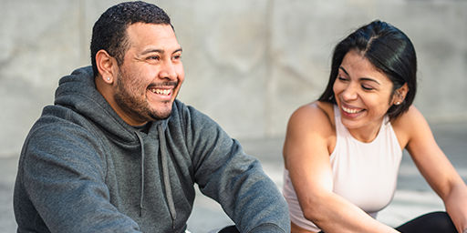 Man and woman laughing sitting in park