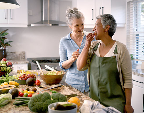 Two senior adults cooking healthy in the kitchen