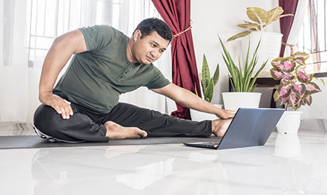 male doing a virtual yoga class at home