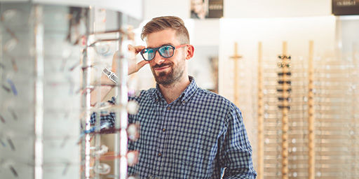hombre probándose anteojos en la tienda