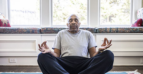 Senior man meditating at home