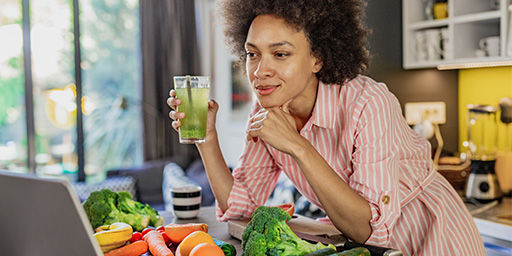 woman is in the kitchen watching a virtual health related video