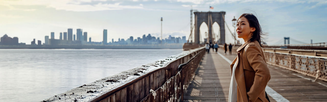 person standing on bridge with hands in pocket