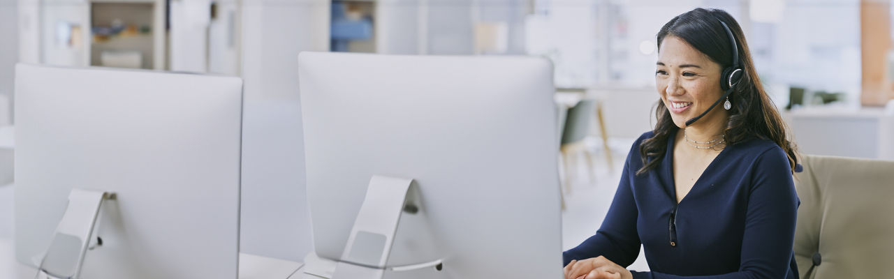 sales agent with headphones at computer