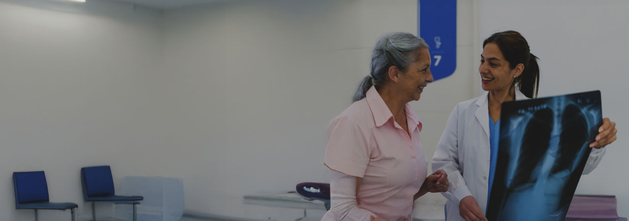 provider holding xray and talking to patient 