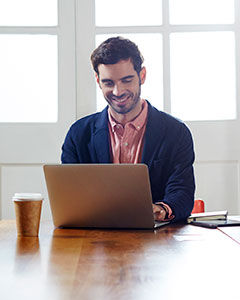 Hombre escribiendo una publicación de blog de EmblemHealth desde su hogar.