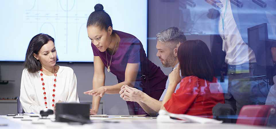 group of business leaders talking at conference table